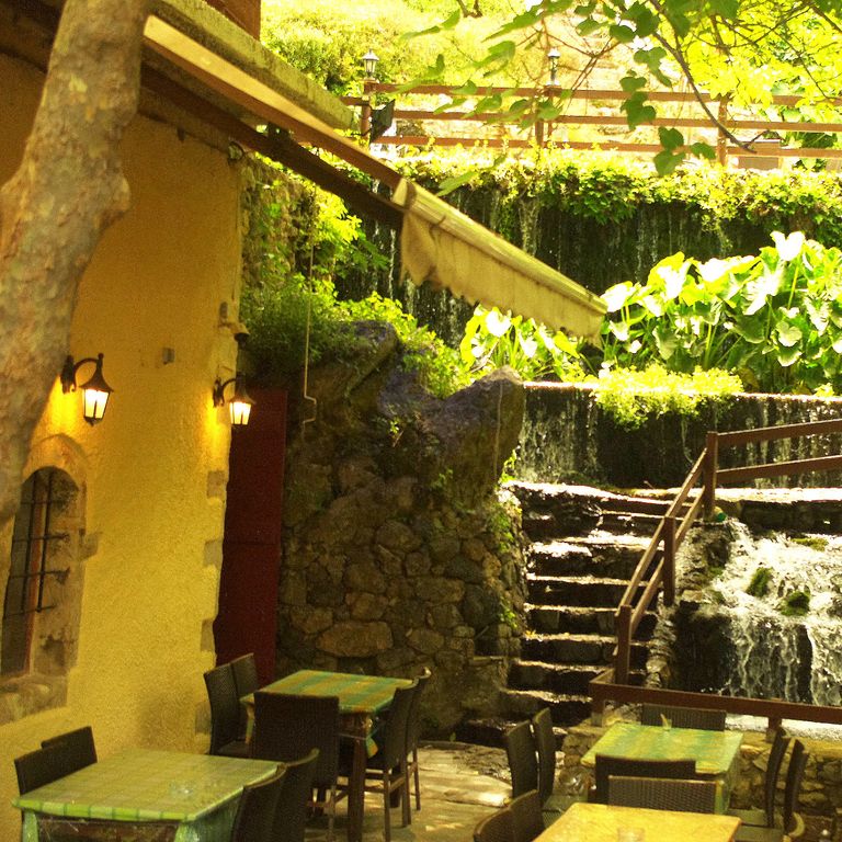 Taverne mit grünem schattenspendenden Laubdach und kühlendem Wasserfall, in dem frische Forellen schwimmen sorgen für ein angenehmes kühles Klima